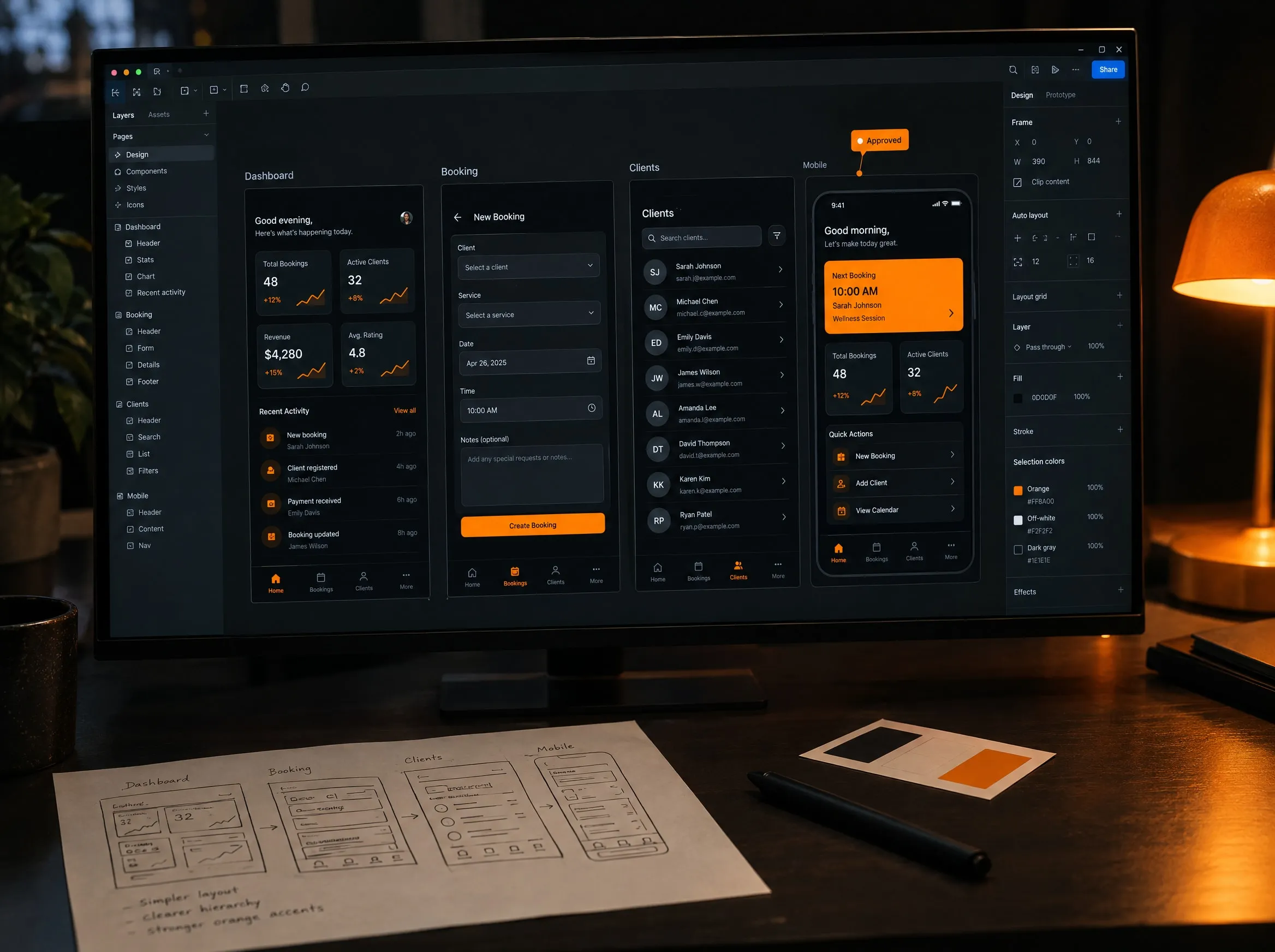 A monitor showing four app screens in a design tool, with wireframe sketches and colour swatches on the desk